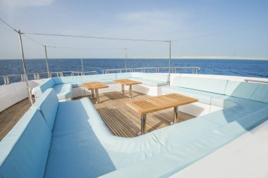 Tik güverte sandalye koltuk masa ve tropikal deniz görünümü arka plan ile büyük lüks motoryat yay