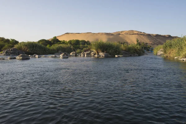 通过乡村景观 沿着埃及阿斯旺的大宽河尼罗河 欣赏乡村景观 并具有岩石性白内障岛屿和山区背景 — 图库照片