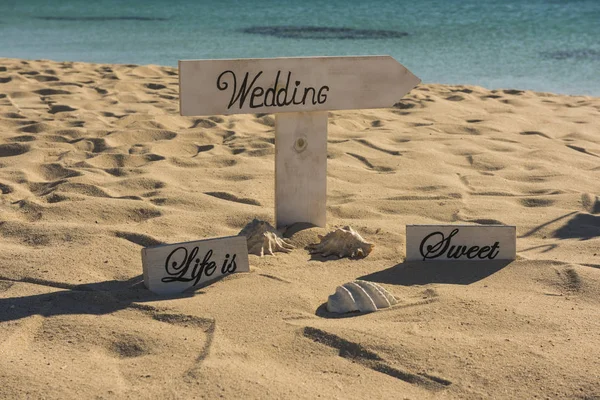 Closeup of wedding sign on tropical island sandy beach paradise with ocean in background