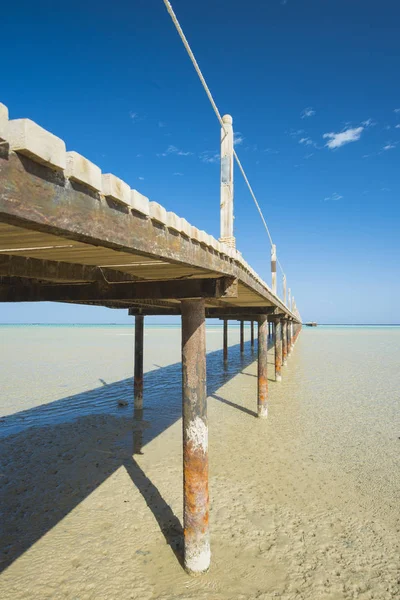 熱帯のビーチから海に出て行く木製の桟橋桟橋 — ストック写真