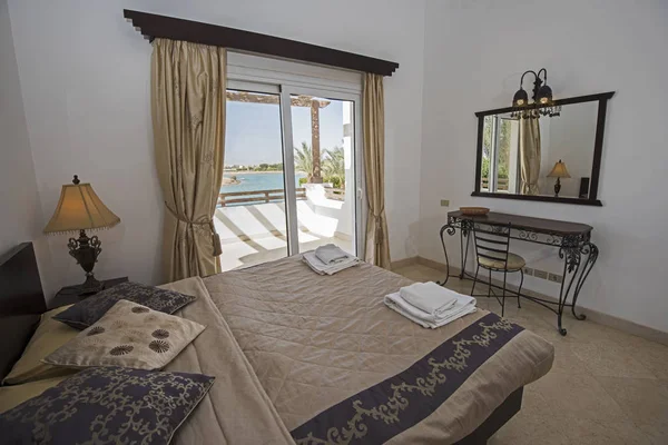 Interior design decor furnishing of luxury show home bedroom with furniture and tropical sea view