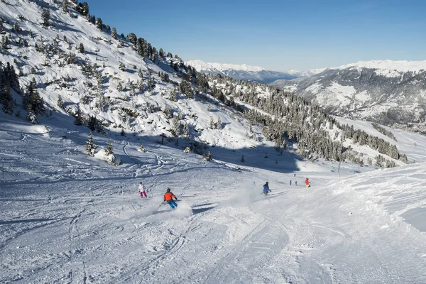 Skifahrer auf der Piste im alpinen Skigebiet lizenzfreie Stockfotos