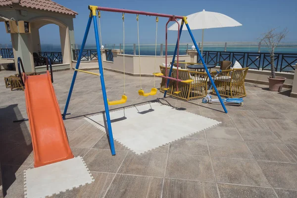 Детская игровая площадка на террасе с видом на море — стоковое фото