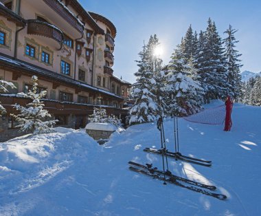 Alpine ski resort with apartments and snowy trees. clipart
