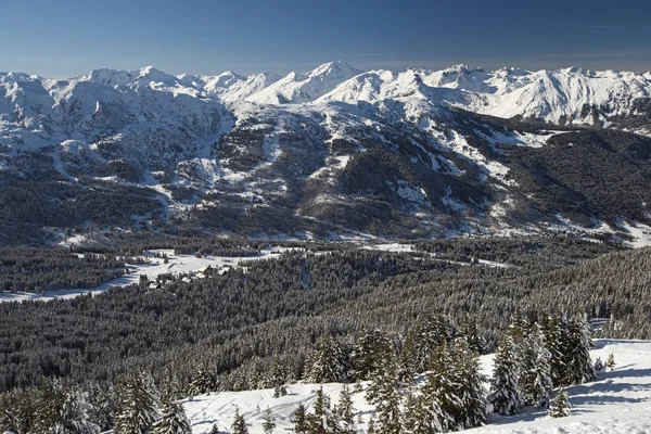 Panoramiczny widok dół śniegiem pokryte valley w alpejskich gór — Zdjęcie stockowe