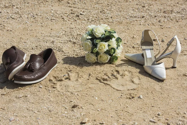 Beach wedding concept with shoes and rings in sand — Stock Photo, Image