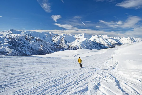 Sciatori su una pista in località sciistica alpina — Foto Stock