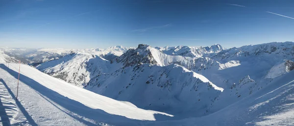 Panoramiczny widok dół śniegiem pokryte valley w alpejskich gór — Zdjęcie stockowe