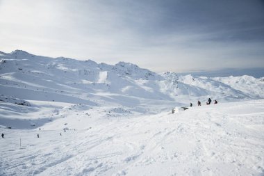 Skiers off piste in alpine ski resort clipart