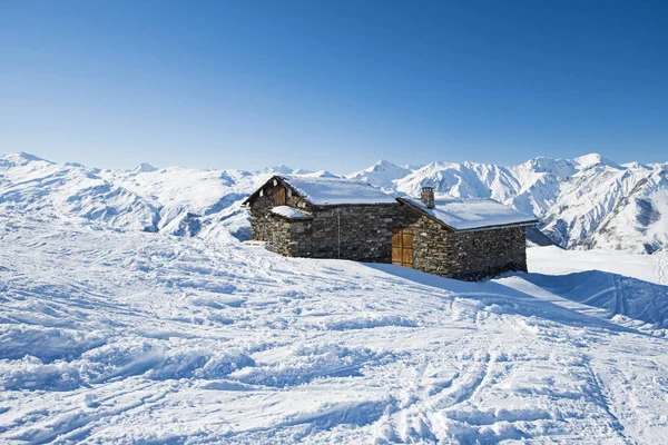 Vista através das montanhas alpinas com pequeno edifício de pedra — Fotografia de Stock