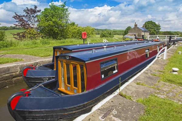 Barcas estrechas en una esclusa en un canal británico en un entorno rural — Foto de Stock