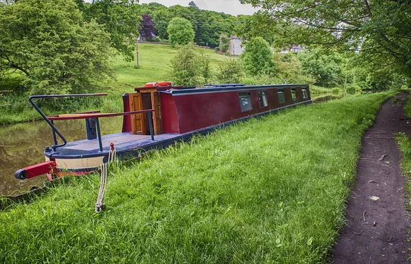 Barco estrecho amarrado en un canal británico en un entorno rural — Foto de Stock