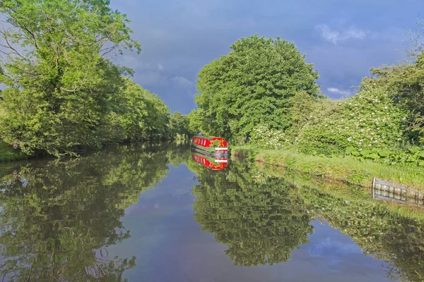 Barco estrecho amarrado en un canal británico en un entorno rural — Foto de Stock