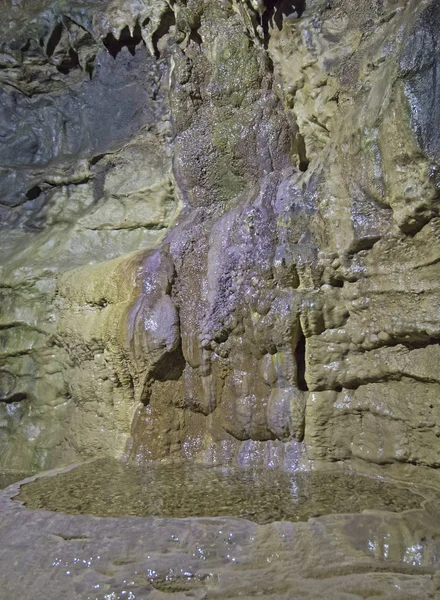 Formações rochosas geológicas e piscina de água em uma caverna subterrânea — Fotografia de Stock