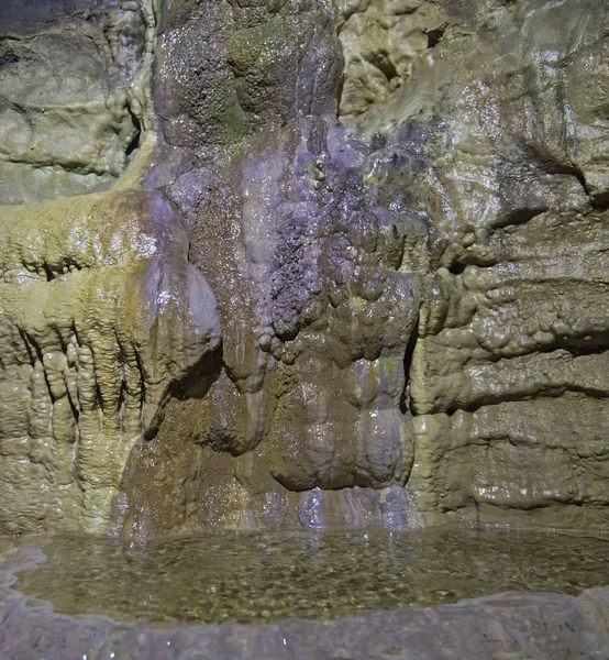 Geologiska bergformationer och vattenpool i en underjordisk grotta — Stockfoto