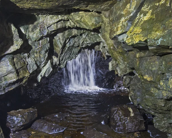 Geologiska bergformationer och vattenfall i en underjordisk grotta — Stockfoto