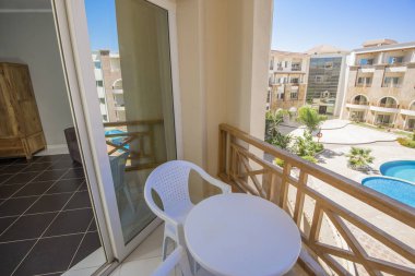 Teras balkonunda sandalyeler ve tropikal lüks apartman dairesi.