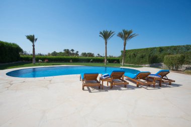 Lüks villa, tropikal yaz tatillerinde yüzme havuzu ve dinlenme yerleri olan evleri gösteriyor.