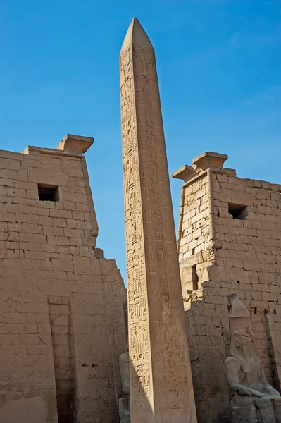 卢克索神庙入口处的塔上有一个高大的古埃及方尖碑 上面刻着象形文字 — 图库照片