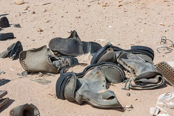 废弃在遥远的非洲沙漠中的旧的腐烂的军靴的遮掩 — 图库照片