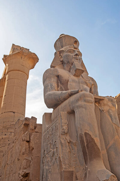 Большая статуя и иероглифическая резьба Рамзеса II в древнем египетском храме Луксора с колоннами
