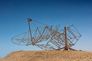 Eski terk edilmiş askeri radar antenleri ıssız bir çöl arazisindeki bir tepede.