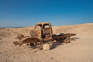 Çölde çürümeye terk edilmiş eski, paslı, terk edilmiş bir kamyonun kalıntıları.