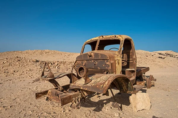 砂漠に残された錆びた古い廃棄物トラックの残骸が崩壊する — ストック写真