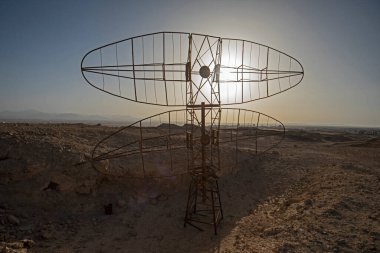 Eski terk edilmiş askeri radar antenine yakın çekim. Uzak Afrika çöllerinde günbatımı ile terk edilmiş.