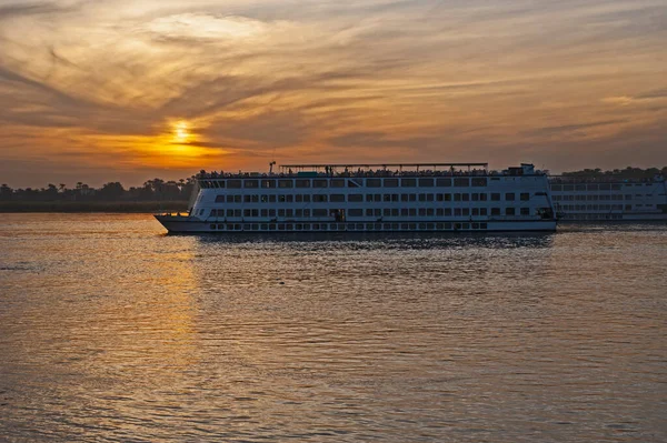 日没時にナイル川を航行する大規模な豪華な伝統的なエジプトの川クルーズボートのペア — ストック写真