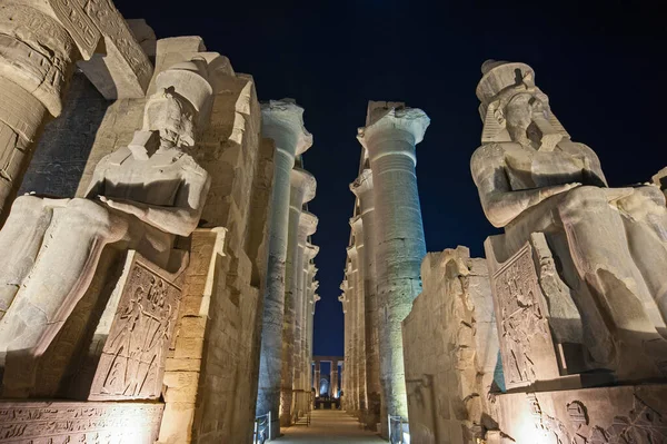 在古埃及卢克索神殿的低矮大厅里点亮了装有柱子的拉美西斯二世的大雕像 — 图库照片
