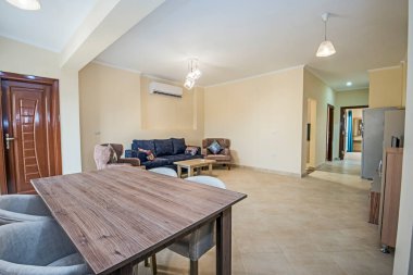 Lüks apartmandaki oturma odasının oturma odası ev dekorasyonunu gösteriyor. Açık planlı yemek alanı döşenmiş.