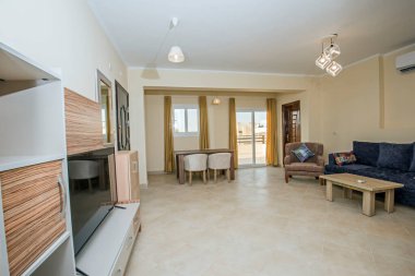 Lüks apartmandaki oturma odasının oturma odası ev dekorasyonunu gösteriyor. Açık planlı yemek alanı döşenmiş.