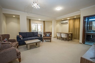 Lüks apartmandaki oturma odasının oturma odası ev dekorasyonunu gösteriyor. Açık planlı yemek alanı döşenmiş.