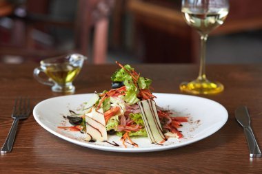 harika bir salata marul, havuç, soğan ile peynir zeytin yağı ve beyaz bir masada şarap, çerçevede orada da bir çatal ve bıçakla hizmet