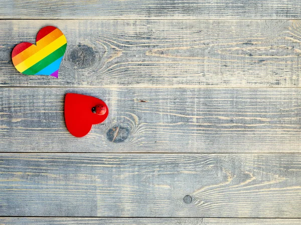Kalp kalpli Lgbt bayrak ve kırmızı ışık mavi üzerinde küçük ladybag yalanla ahşap tahta dokulu, kutlama için tasarım bilgileri yerleştirmek için boş alanı olan