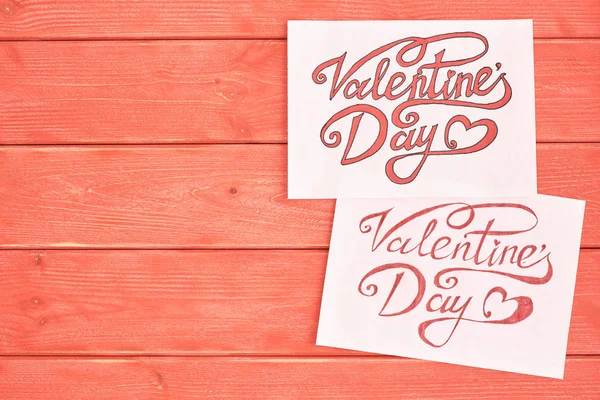 Due fogli bianchi di carta con un messaggio, lettera a San Valentino, legno pino sfondo colore corallo vivente — Foto Stock