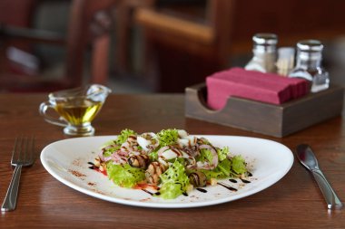 Lezzetli deniz ürünleri salata karides, ahtapot, midye, mürekkep balığı ve tarak ile sebze kabukları, çatal ve peçete masanın üzerinde duran, yakın çekim, restoran menü veya Web sitesi tasarımı için