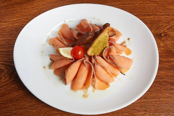 lezzetli doldurma, petrol, kiraz domates ve bir dilim limon, batırılmış kızarmış kraker ile füme somon fileto dilimlenmiş beyaz tabak içinde yalan, düz yatıyordu, en iyi görünümü, kapat