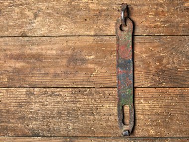 Motor yağı ve çiziklerden oluşan eski kahverengi ahşap kalaslar paslı bir parça asarlar.