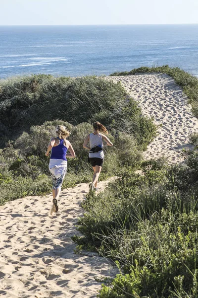 Twee Vrouwen Die Het Zand Rennen — Stockfoto