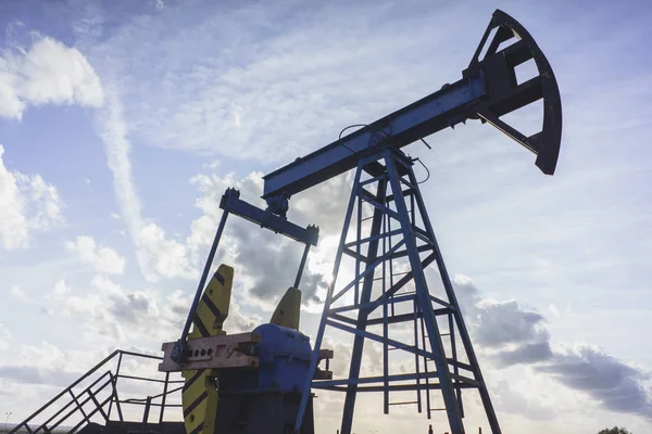 Produção de óleo: equipamento de óleo no fundo do céu azul — Fotografia de Stock
