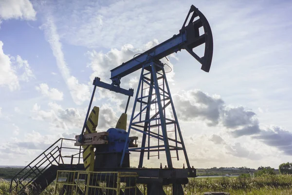 Produção de óleo: equipamento de óleo no fundo do céu azul — Fotografia de Stock