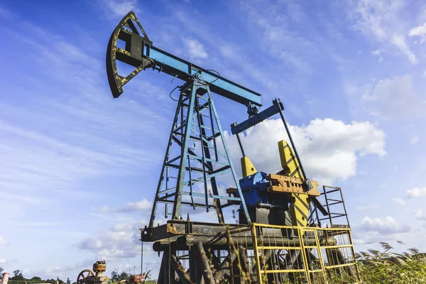 Добыча нефти: Нефтяная вышка на фоне голубого неба — стоковое фото