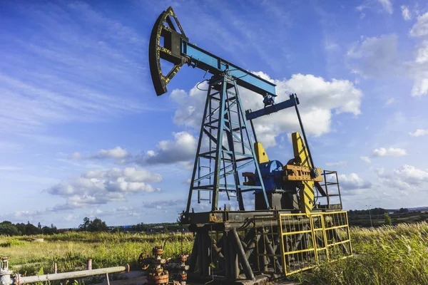 Добыча нефти: Нефтяная вышка на фоне голубого неба — стоковое фото