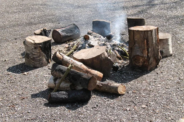 A Gently Smouldering Large Outdoor Wood Log Fire.