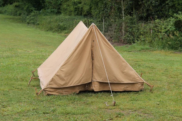 An Old Brown Canvas Camping Tent with Wooden Pegs.