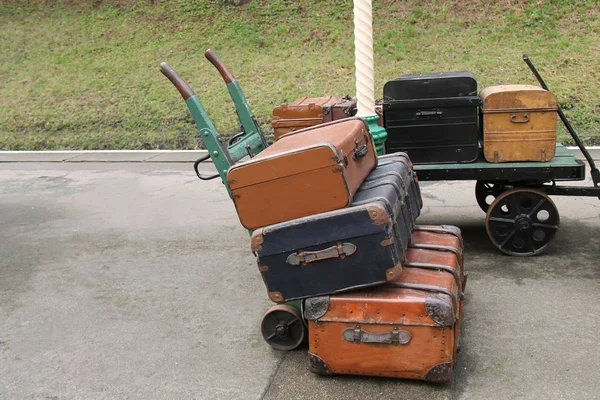 Two Railway Station Luggage Trollies with Cases.
