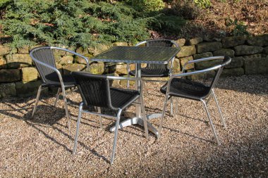 Bir Masa ve Dört Metal Çerçeveli Sandalye Bahçesi.