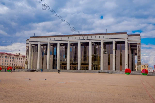 MINSK, BÉLARO - 01 DE MAYO DE 2018: Vista al aire libre de los turistas caminando en el Palacio de la República es un centro cultural y de negocios bielorruso situado en la Plaza de Octubre de Minsk —  Fotos de Stock